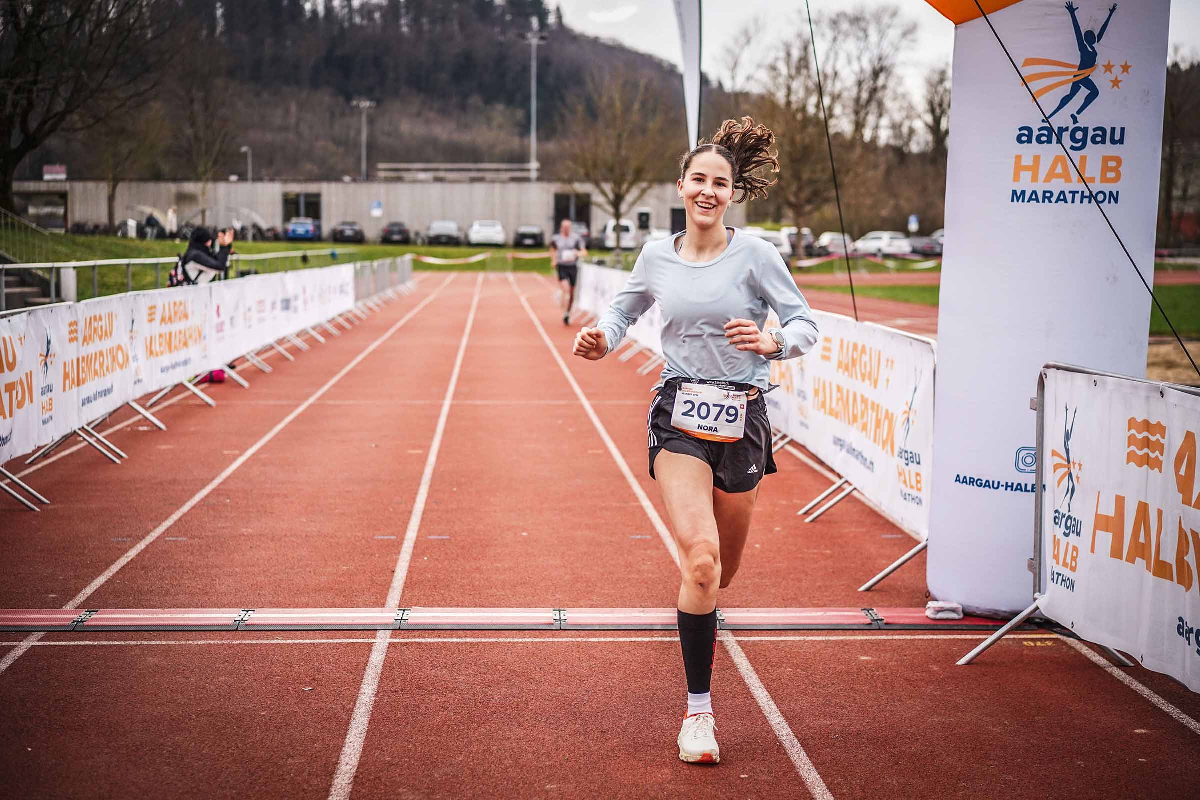 female runner at finish line smiling